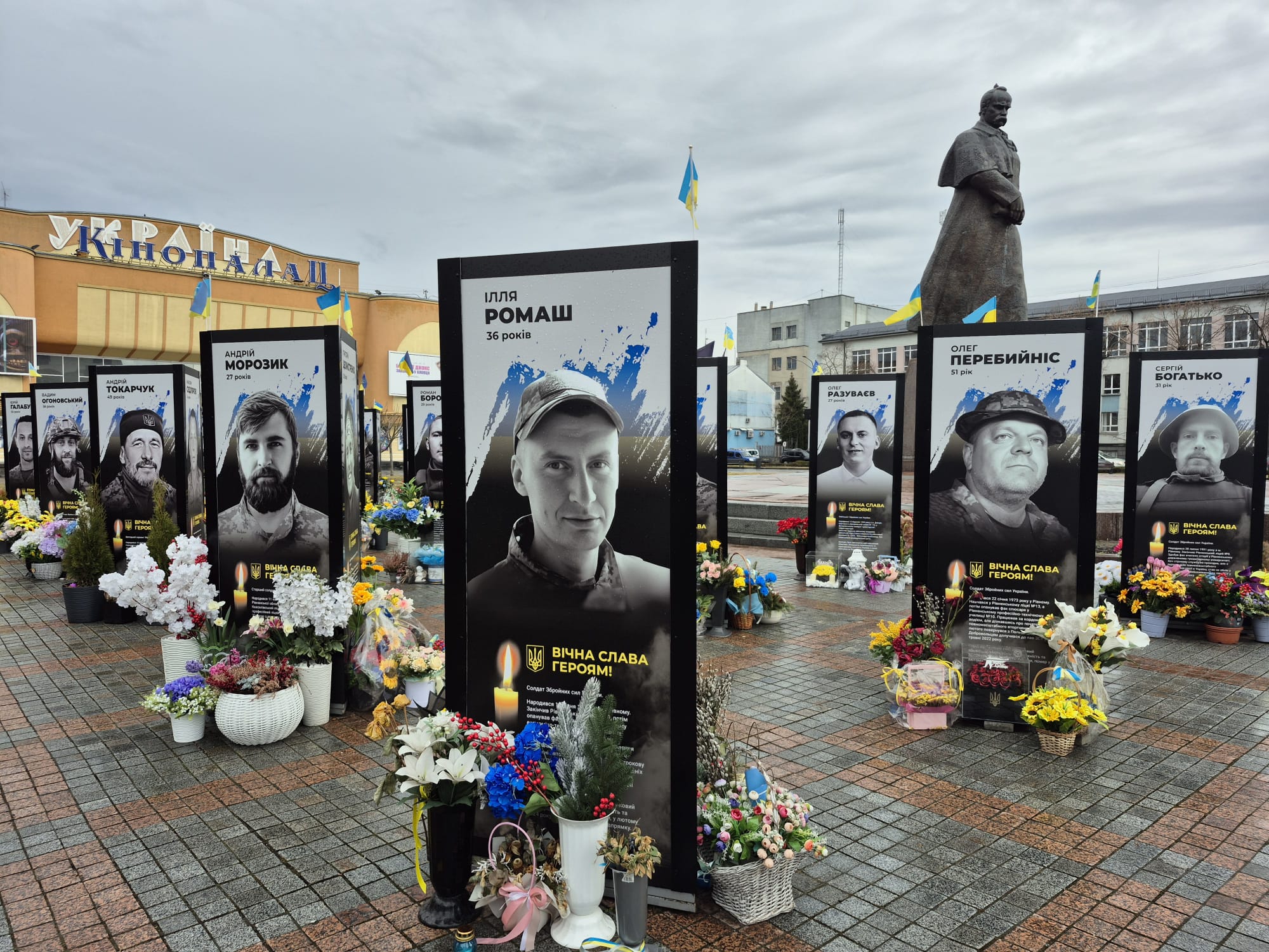 Пам'ятні стели полеглим українським воїнам із квітами та свічками